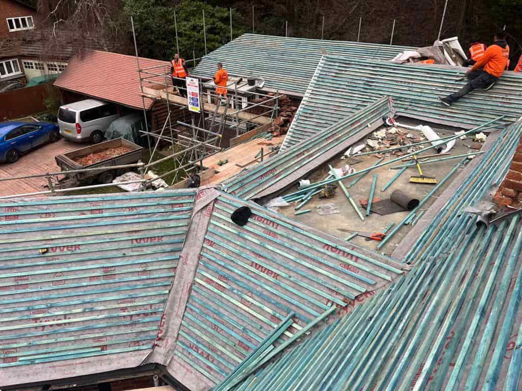 This is a photo of a large re-roof being carried out by SCG Roofing Earls Barton, there are multiple sections of pitched roofs adjoining to a central flat roof